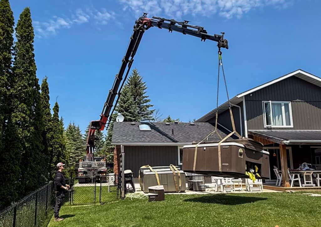 We are using a Palfinger Knuckle crane to lift a hot tub into a backyard.