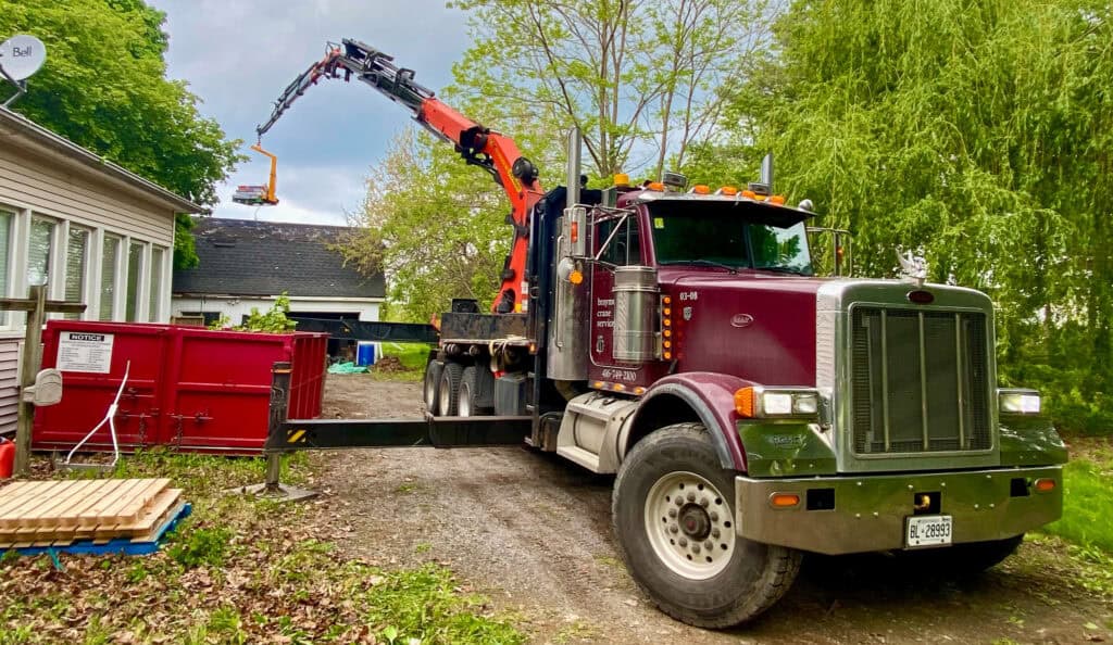 We are using a Palfinger knuckle crane with a forklift attachment to lift skids up on to roof for workers.